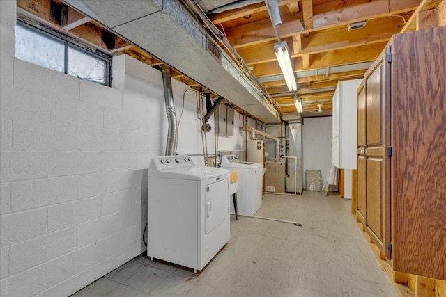 laundry area featuring separate washer and dryer, water heater, and light floors