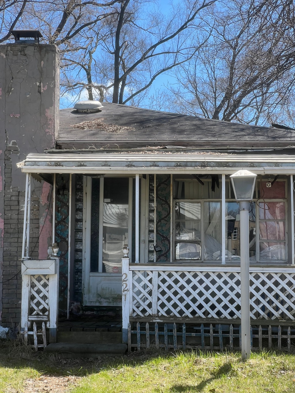 back of house featuring a chimney and a porch