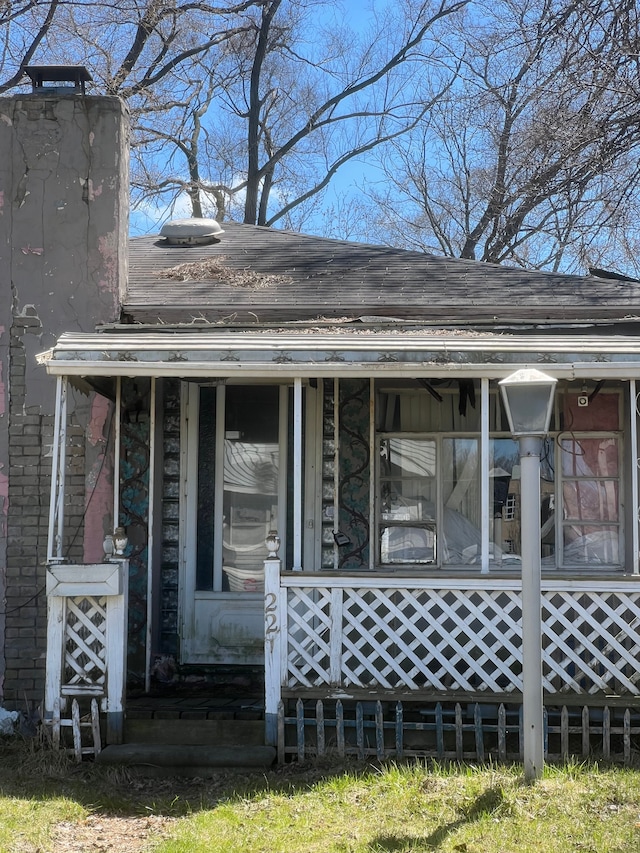 back of house featuring a chimney and a porch