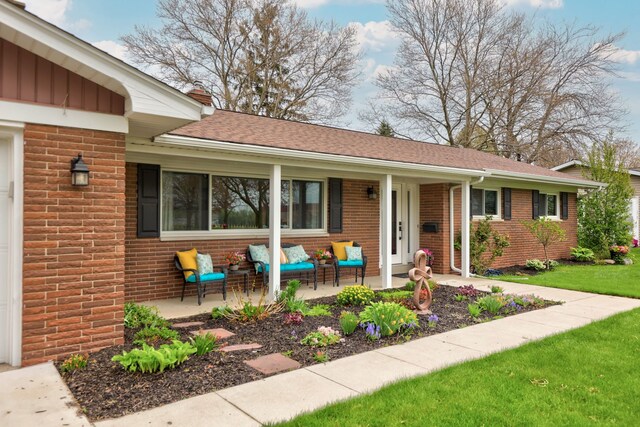 932 E Genesee St, Frankenmuth, MI 48734 - single story home with covered porch, brick siding, roof with shingles, and a front lawn