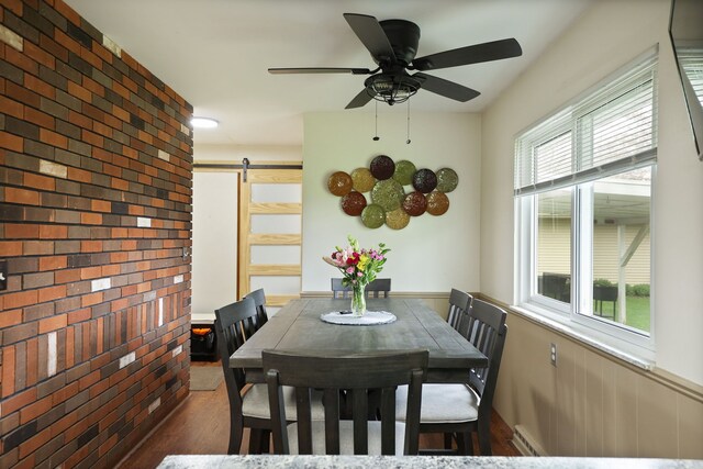 932 E Genesee St, Frankenmuth, MI 48734 - dining area featuring a barn door, baseboard heating, wood finished floors, and a ceiling fan