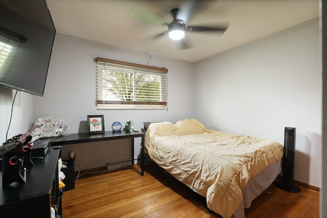 932 E Genesee St, Frankenmuth, MI 48734 - bedroom with light wood-style floors, a baseboard heating unit, and ceiling fan
