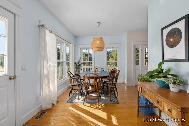 2445 Honey Creek Ave NE, Ada, MI 49301 - dining space with light wood-style flooring and baseboards