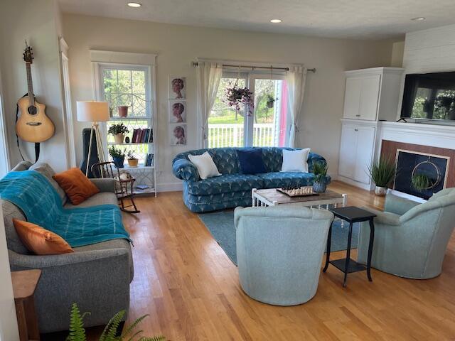 2445 Honey Creek Ave NE, Ada, MI 49301 - living room featuring wood finished floors, healthy amount of natural light, a fireplace, and recessed lighting