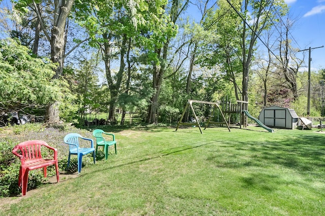 view of green lawn with a storage unit, an outbuilding, and a playground