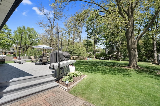 view of yard featuring a wooden deck and outdoor dining space