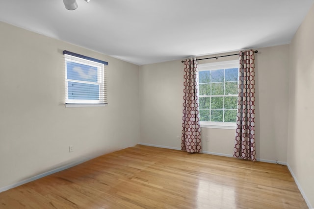 empty room with light wood-type flooring and baseboards