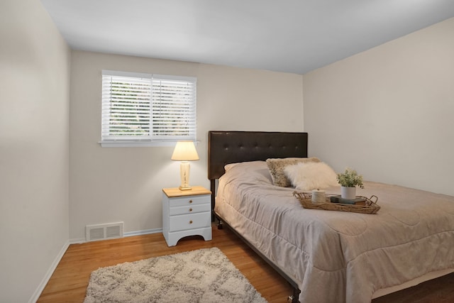 bedroom with wood finished floors and baseboards