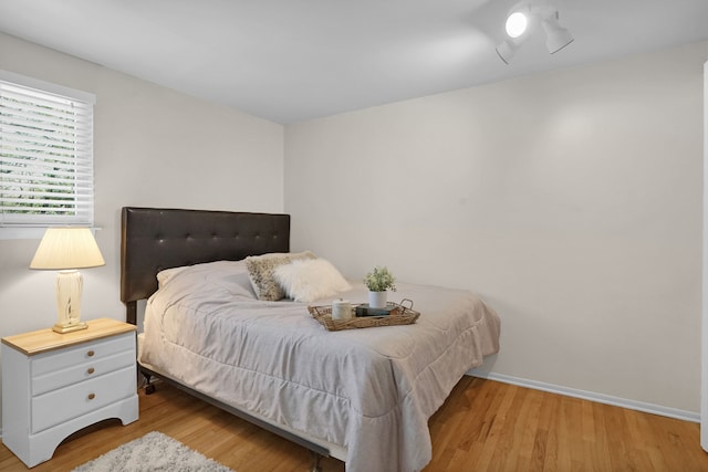 bedroom featuring wood finished floors and baseboards