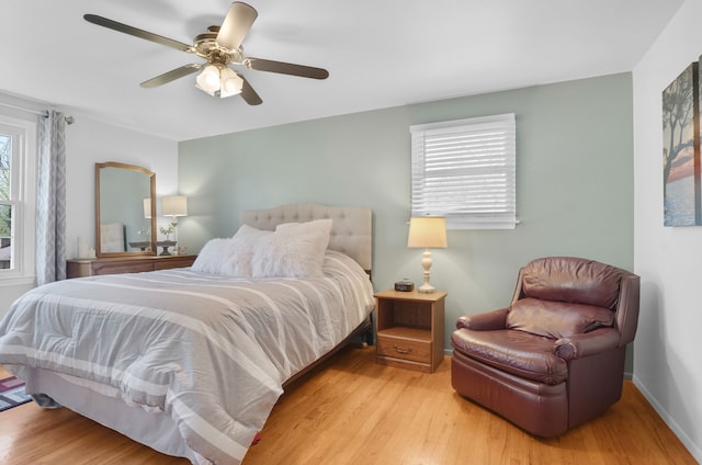 bedroom featuring wood finished floors, baseboards, and ceiling fan