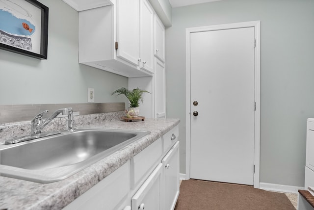 kitchen featuring a sink, white cabinets, light countertops, and light colored carpet