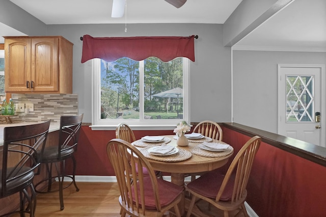 dining space featuring a ceiling fan, light wood-style flooring, and baseboards