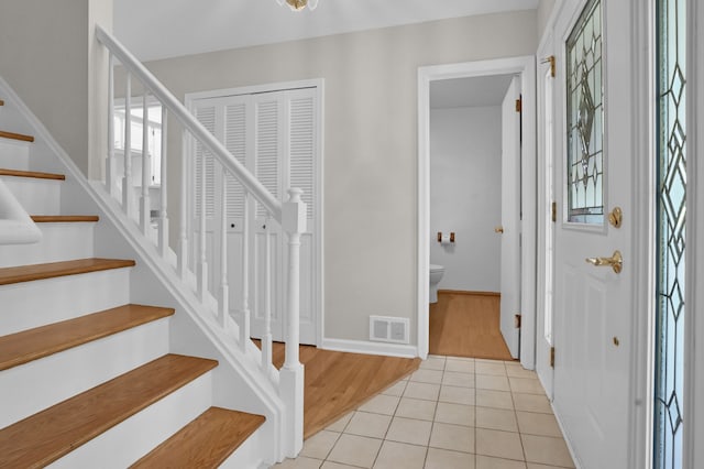 foyer entrance with stairs and light tile patterned floors