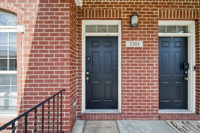 view of exterior entry featuring brick siding