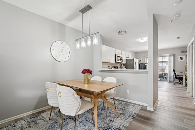 dining area with wood finished floors and baseboards