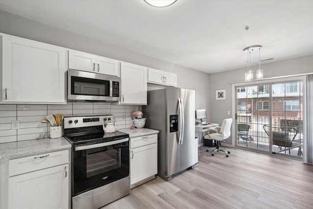 kitchen with appliances with stainless steel finishes, white cabinetry, backsplash, light wood finished floors, and light stone counters