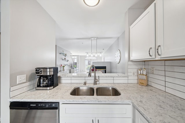 kitchen with dishwasher, a sink, white cabinetry, and light stone counters