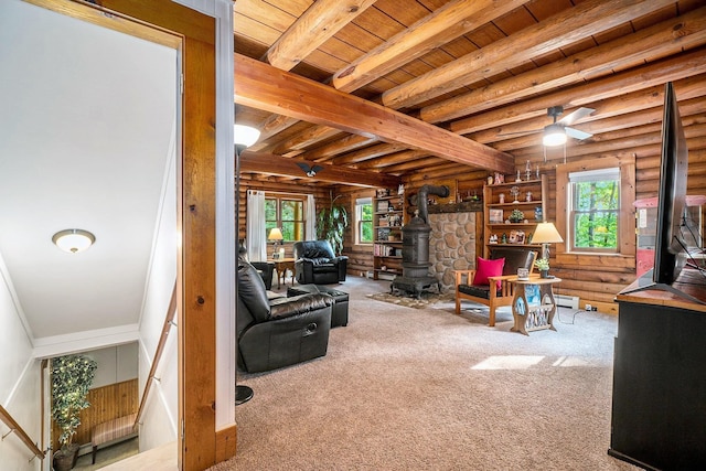 10780 S 29th Rd, Cadillac, MI 49601 - carpeted living area featuring a wood stove, log walls, wooden ceiling, beamed ceiling, and ceiling fan