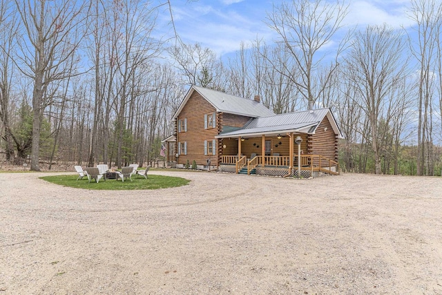 10780 S 29th Rd, Cadillac, MI 49601 - back of house with log siding, a fire pit, driveway, and metal roof