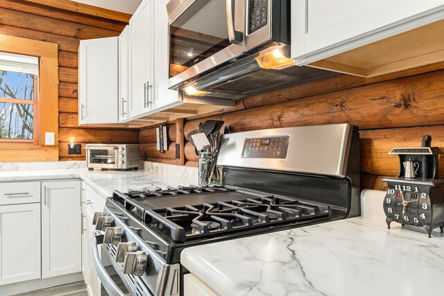 10780 S 29th Rd, Cadillac, MI 49601 - kitchen featuring appliances with stainless steel finishes, rustic walls, white cabinets, and light stone counters