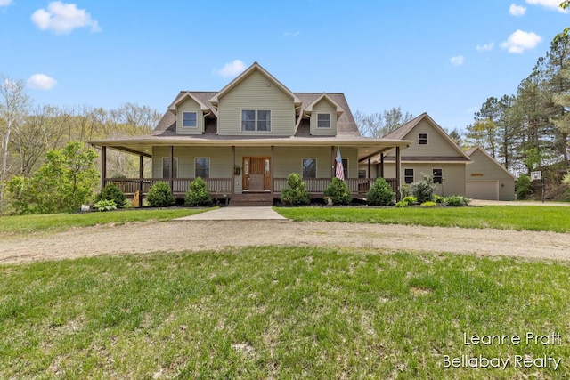 3389 Shultz Rd, Hastings, MI 49058 - farmhouse-style home with covered porch, a front lawn, driveway, and a detached garage