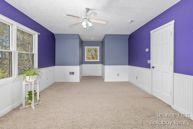 3389 Shultz Rd, Hastings, MI 49058 - spare room featuring wainscoting, ceiling fan, carpet flooring, a textured ceiling, and a smoke detector