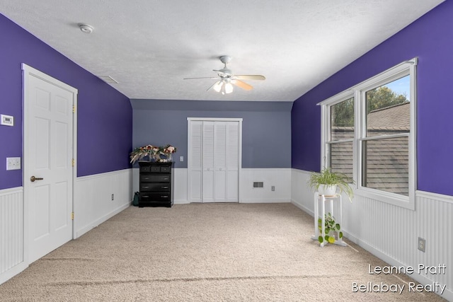 3389 Shultz Rd, Hastings, MI 49058 - unfurnished bedroom featuring wainscoting, carpet floors, a closet, and ceiling fan