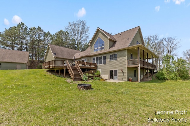 3389 Shultz Rd, Hastings, MI 49058 - rear view of house with a fire pit, a deck, a lawn, and stairs