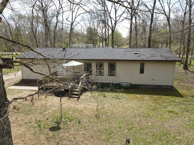 back of house with a wooden deck and a lawn