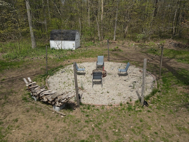 view of yard with a storage unit, an outdoor structure, and an outdoor fire pit