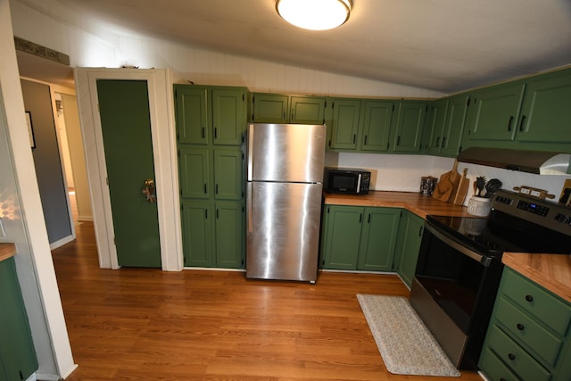 kitchen with stainless steel appliances, vaulted ceiling, green cabinetry, light wood-style flooring, and butcher block countertops