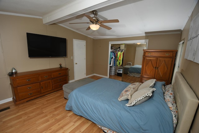 bedroom featuring light wood finished floors, crown molding, a closet, baseboards, and ceiling fan