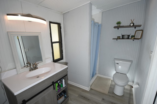 full bathroom featuring toilet, wood finished floors, a shower stall, vanity, and baseboards