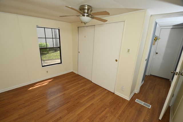 unfurnished bedroom with wood finished floors, a ceiling fan, baseboards, and a closet