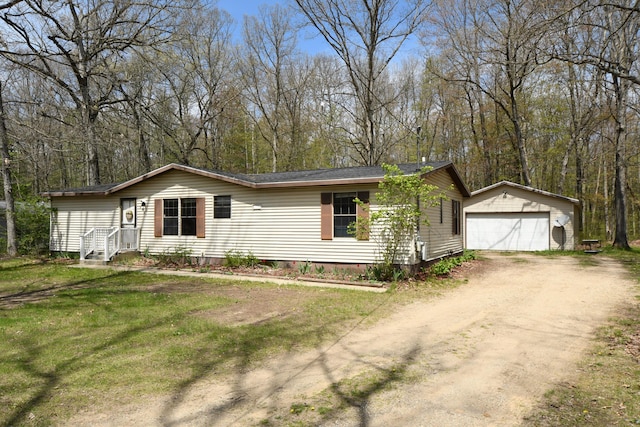 view of front of property featuring crawl space, an outbuilding, a garage, dirt driveway, and a front lawn