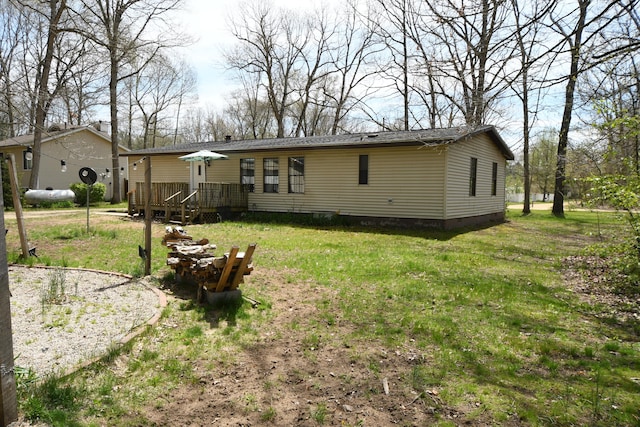rear view of house with a deck and a lawn