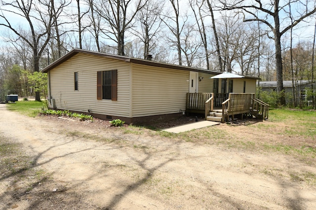 rear view of house with crawl space and a wooden deck