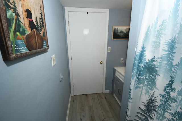 doorway featuring light wood finished floors and baseboards