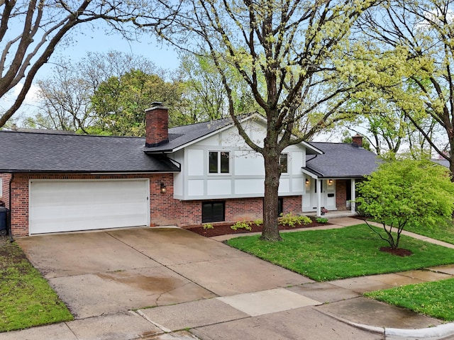 tri-level home featuring a chimney, brick siding, a garage, and a front lawn