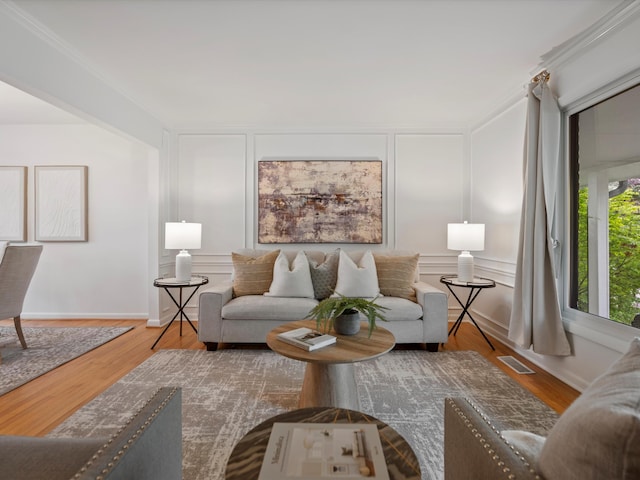 living area featuring a decorative wall, wood finished floors, and baseboards