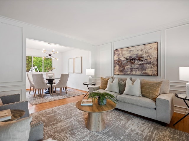 living area with a decorative wall, wood finished floors, and a chandelier