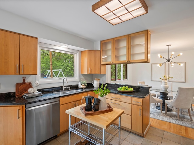 kitchen featuring dishwasher, a sink, plenty of natural light, and light tile patterned flooring