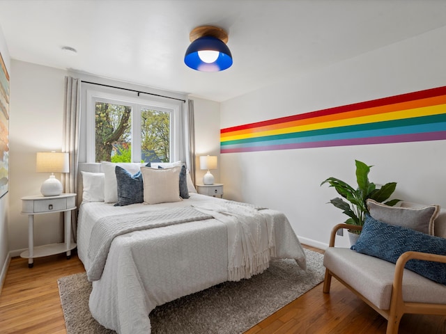 bedroom with wood finished floors and baseboards