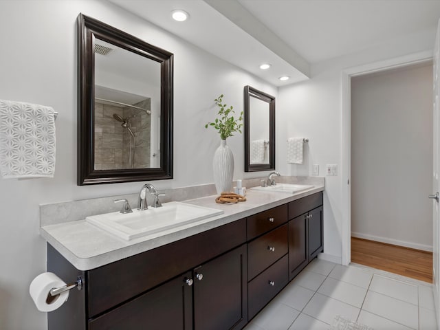bathroom featuring tile patterned floors, recessed lighting, double vanity, and baseboards
