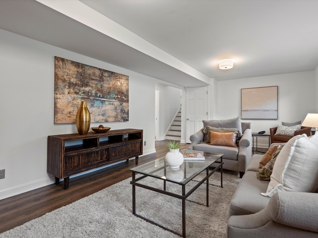 living room featuring stairs, wood finished floors, and baseboards