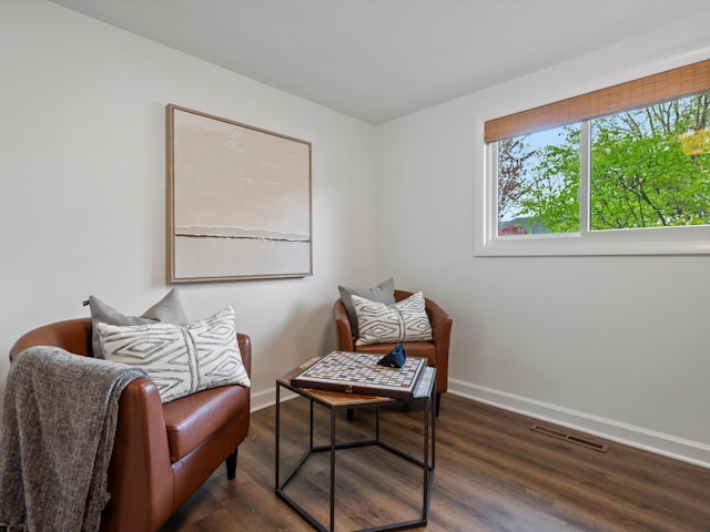 sitting room with baseboards and wood finished floors
