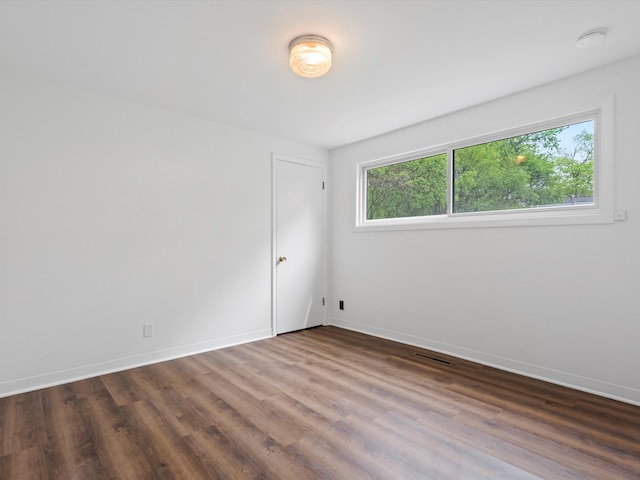 spare room with wood finished floors and baseboards