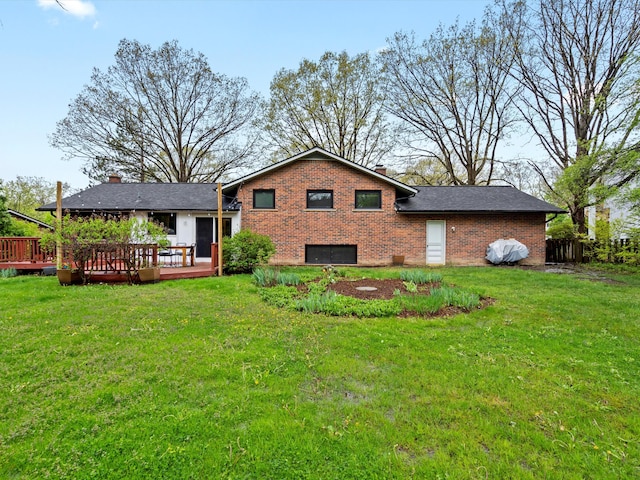 back of property with brick siding, a deck, a lawn, and a chimney