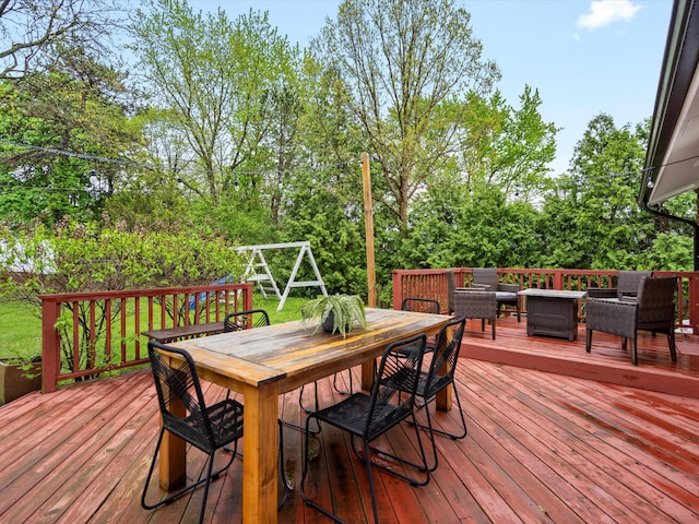 deck featuring outdoor dining space, an outdoor hangout area, and view of wooded area