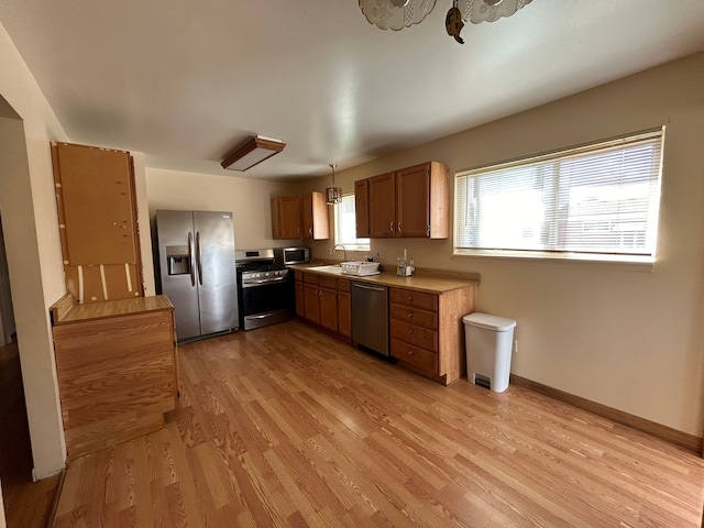 23851 Annapolis St, Dearborn Heights, MI 48125 - kitchen featuring appliances with stainless steel finishes, light wood-style floors, brown cabinets, a sink, and light countertops
